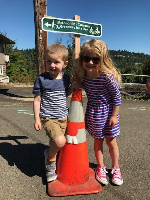 Children Smiling Next to a Cone in Front of the Greenway for a Day Sign
