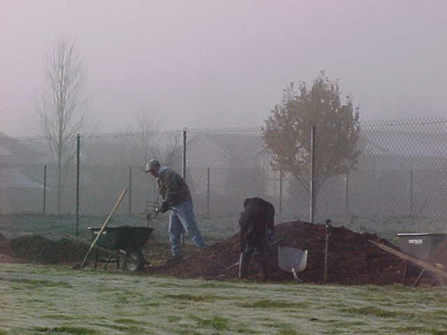 Two People Next to Pile of Dirt